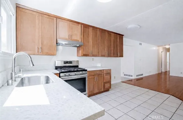 a kitchen with stainless steel appliances granite countertop a sink stove and cabinets