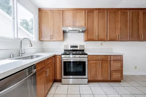 a kitchen with stainless steel appliances a stove a sink and a microwave