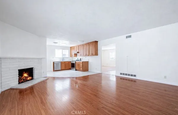 a view of a livingroom with wooden floor and a fireplace