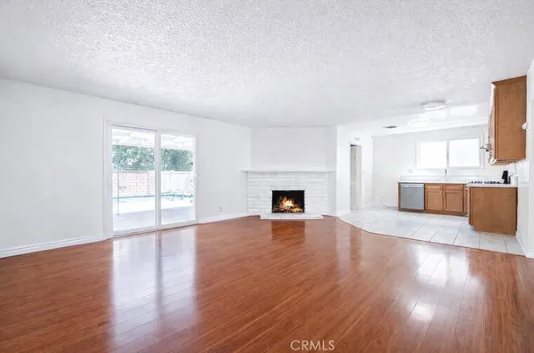 a view of a livingroom with wooden floor and a fireplace