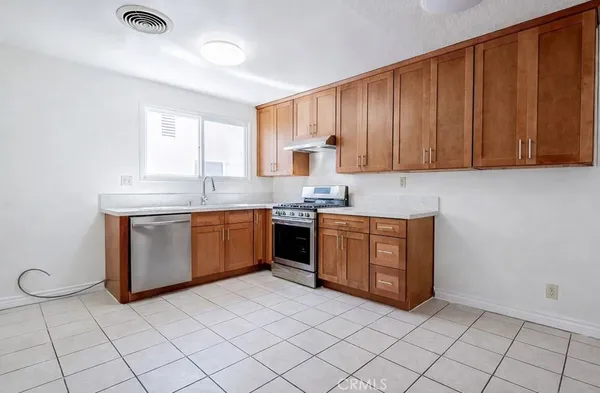 a kitchen with stainless steel appliances granite countertop a stove a sink dishwasher and a refrigerator