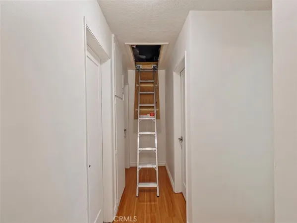 a view of a hallway with wooden floor and entryway