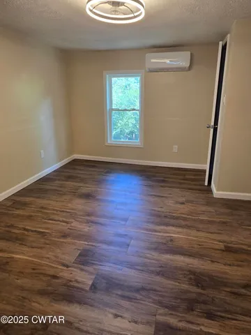 an empty room with wooden floor and window