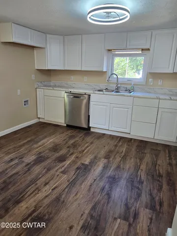 a kitchen with a sink cabinets a window and a rug