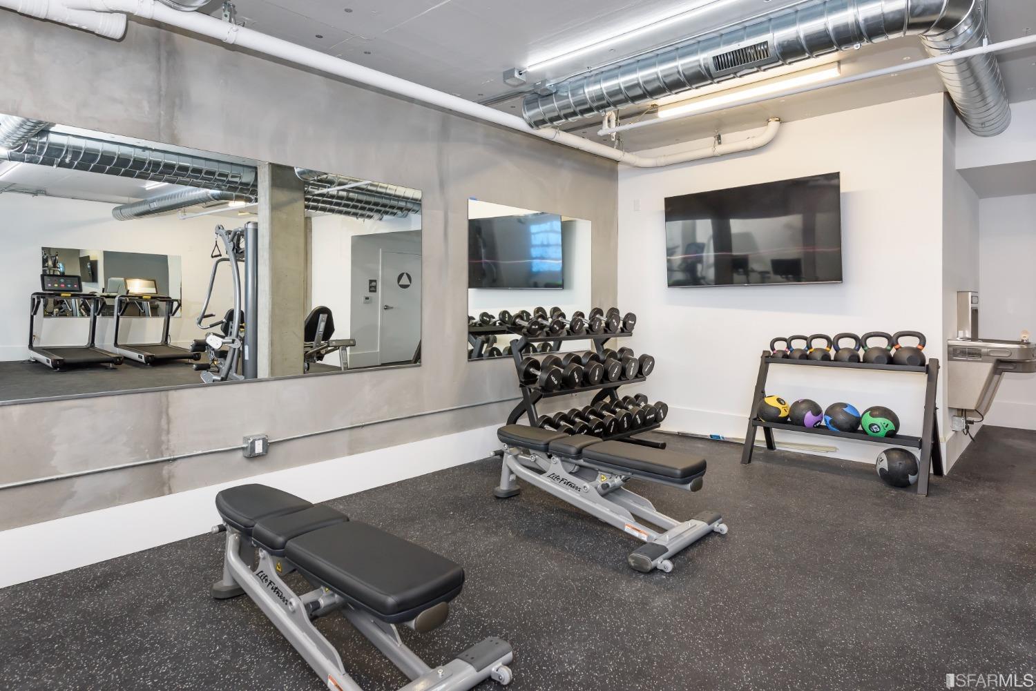 1288 Howard Street, Unit 403 San Francisco, CA 94103 - Photo 22 of 33 a living room with gym equipment and a flat screen tv