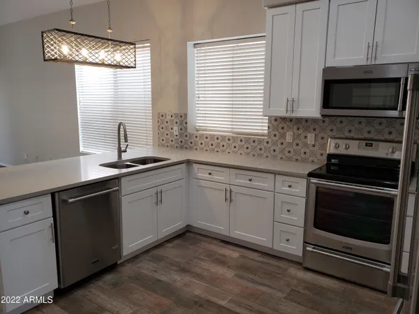 a kitchen with a sink stove and microwave