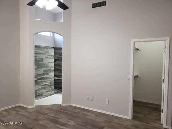 a view of an empty room with a chandelier fan