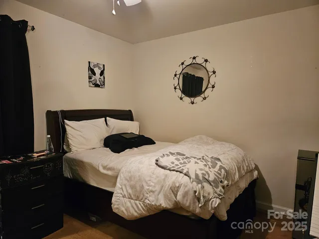 a bedroom with a bed and painting on the wall
