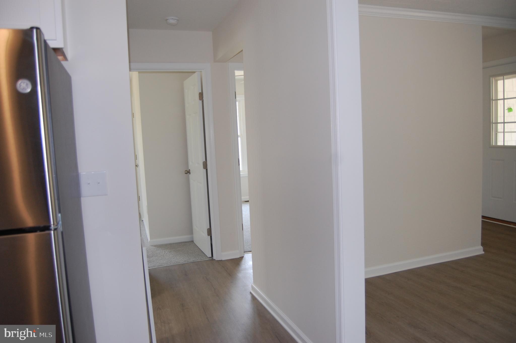 11511 Old School Road Mardela Springs, MD 21837 - Photo 12 of 34 a view of hallway with a refrigerator and wooden floor