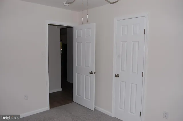 an empty room with closet and a bathroom