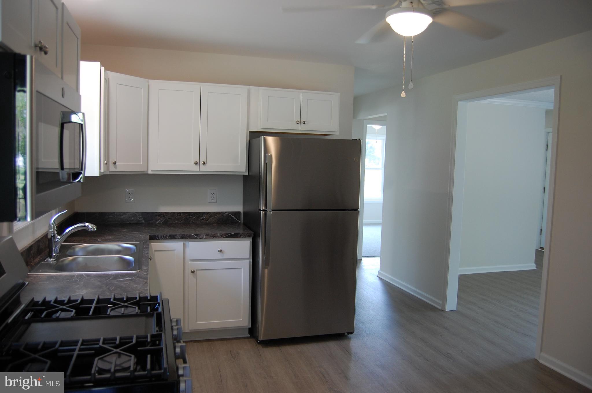 11511 Old School Road Mardela Springs, MD 21837 - Photo 7 of 34 a kitchen with a refrigerator and a sink