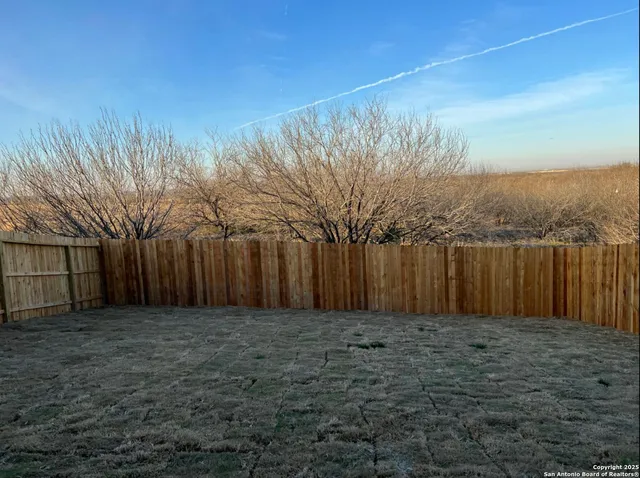 a view of a dining room with furniture a potted plant and wooden floor