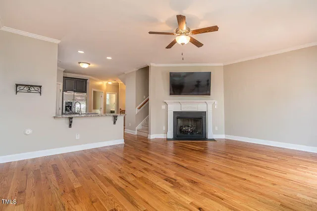 a view of a livingroom with wooden floor and a ceiling fan