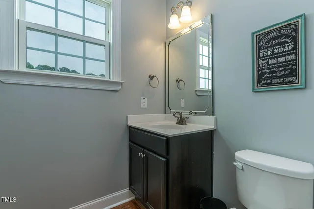 a bathroom with a sink a toilet and a mirror