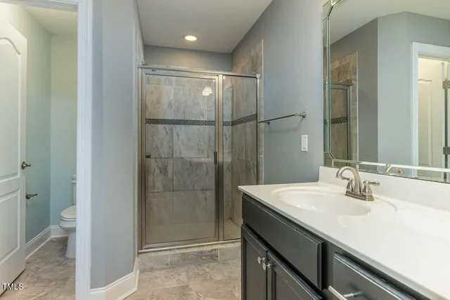 a bathroom with a shower sink vanity and mirror
