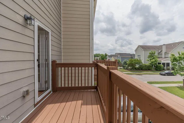 a balcony with view of car parked on street side