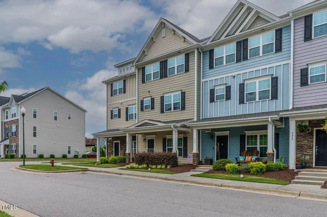 a front view of a brick building next to a yard