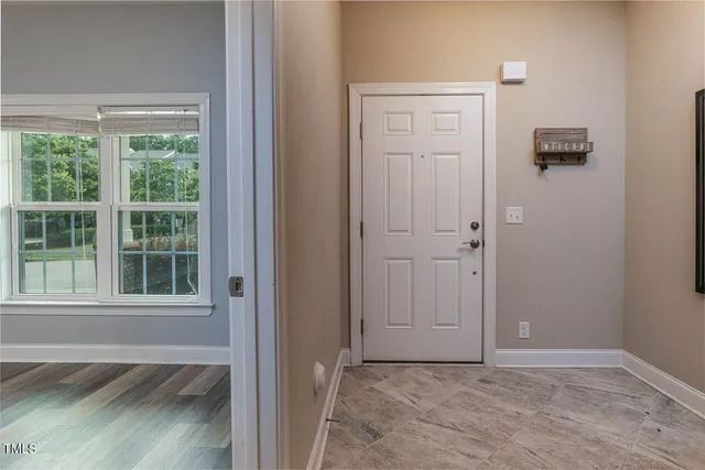 an empty room with a window and wooden floor