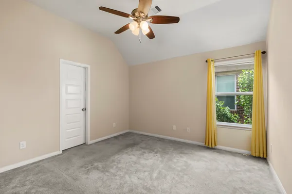 an empty room with chandelier fan