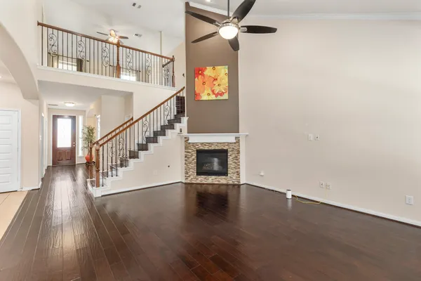 a view of an empty room with wooden floor and a fireplace