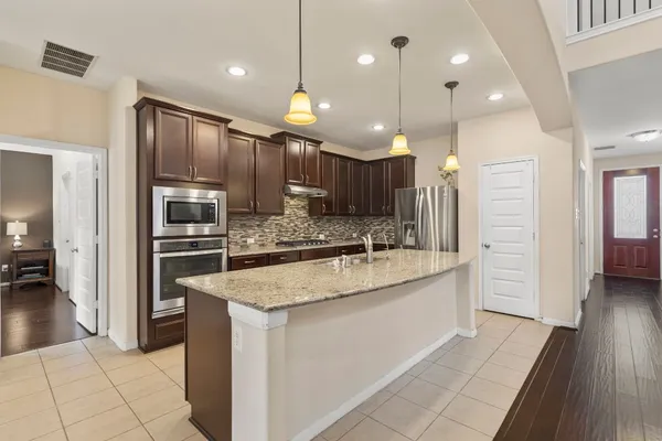 a kitchen with stainless steel appliances granite countertop a sink stove and cabinets
