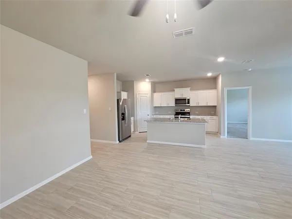 a kitchen with sink a microwave a refrigerator and cabinets