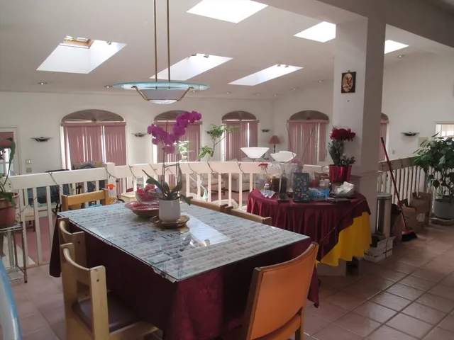 a kitchen with stainless steel appliances granite countertop a dining table and chairs