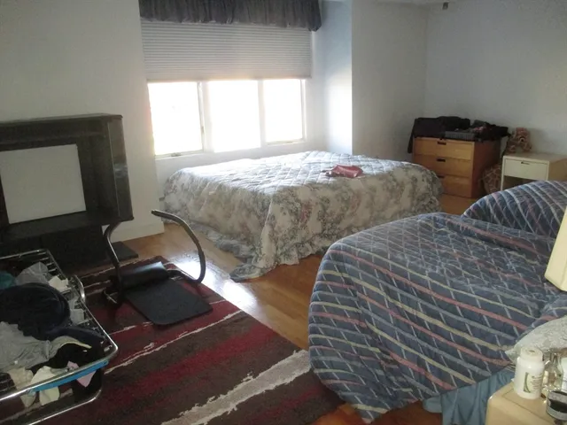 a bedroom with two beds and a window