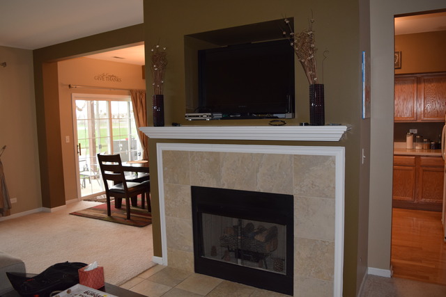 2370 Georgetown Circle, Unit 2370 Aurora, IL 60503 - Photo 3 of 21 a living room with a fireplace and a flat screen tv