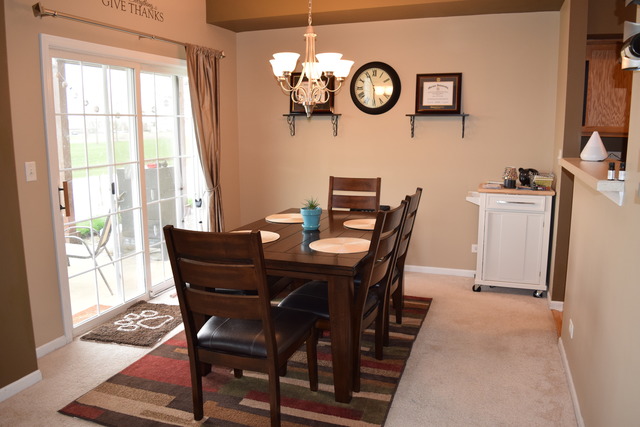 2370 Georgetown Circle, Unit 2370 Aurora, IL 60503 - Photo 6 of 21 a view of a dining room with furniture a rug and wooden floor