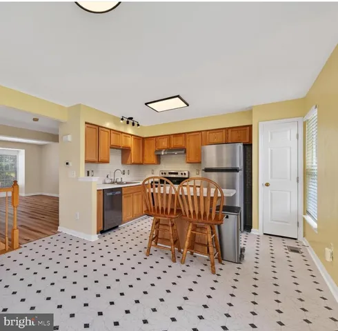 a kitchen with a sink a stove cabinets and a dining table