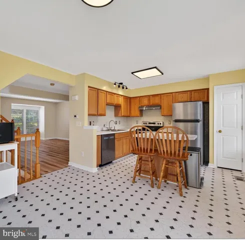 a kitchen with a sink a stove cabinets and wooden floor