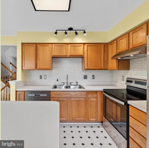 a kitchen with stainless steel appliances a sink stove and cabinets