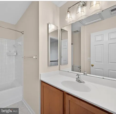 a bathroom with a sink double vanity granite tub shower and a mirror