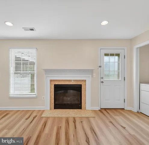 a view of an empty room with a fireplace and a window