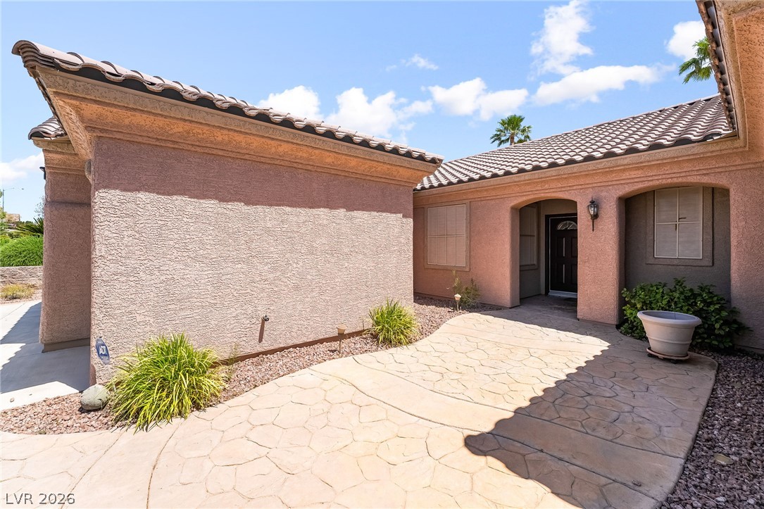3033 Hartsville Road Henderson, NV 89052 - Photo 6 of 41 A terracotta-tiled roof crowns this charming home, featuring an inviting arched entryway.