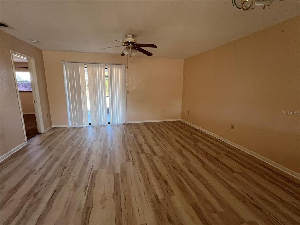 27082 Adams Street, Unit A Punta Gorda, FL 33983 - Photo 2 of 8 a view of a room with wooden floor ceiling fan and windows