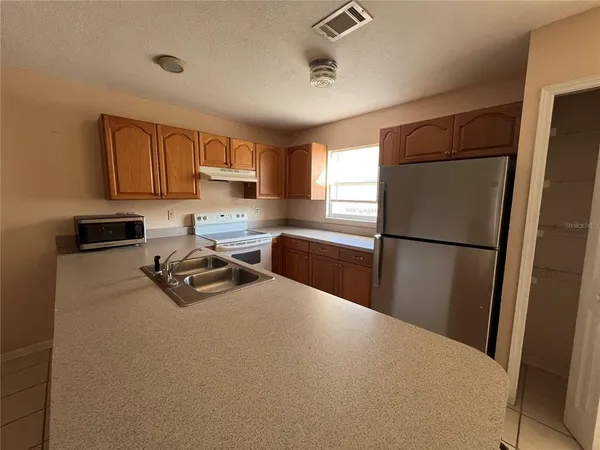 a kitchen with sink refrigerator and cabinets