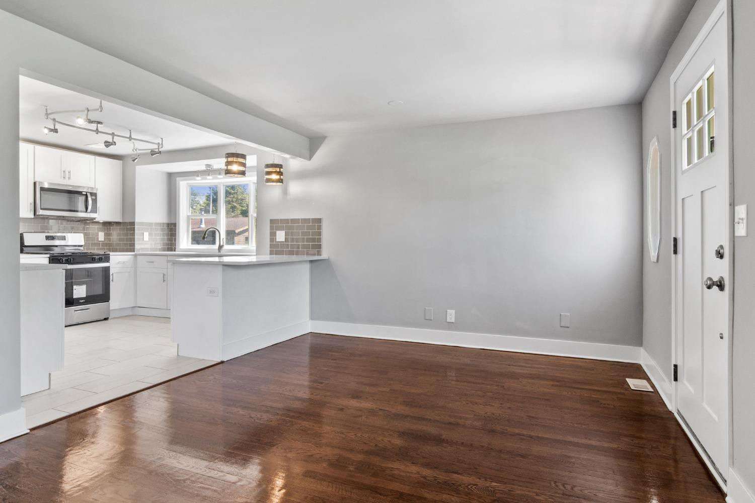 4895 Cherry Street Griffith, IN 46319 - Photo 11 of 21 an empty room with wooden floor and kitchen