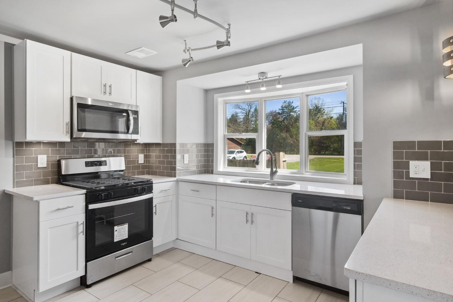 4895 Cherry Street Griffith, IN 46319 - Photo 4 of 21 a kitchen with granite countertop a stove top oven microwave and a refrigerator