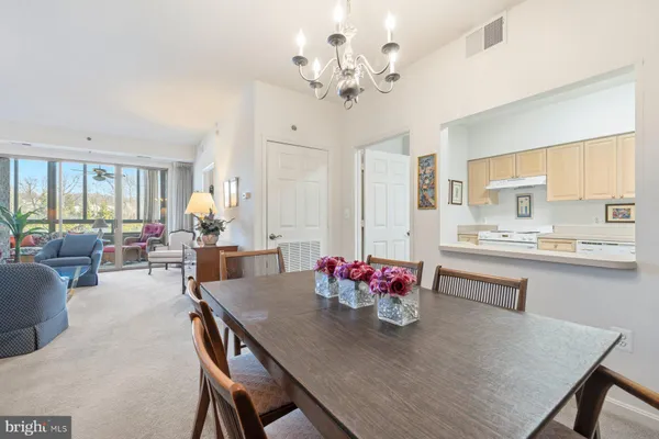 a view of a dining room with furniture and a chandelier