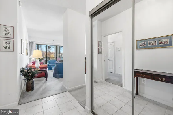a view of a hallway and a livingroom with furniture