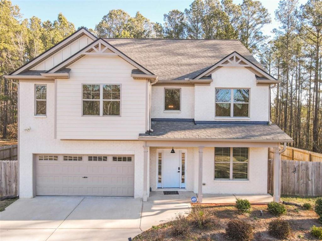 a view of a white house with large windows and a large tree