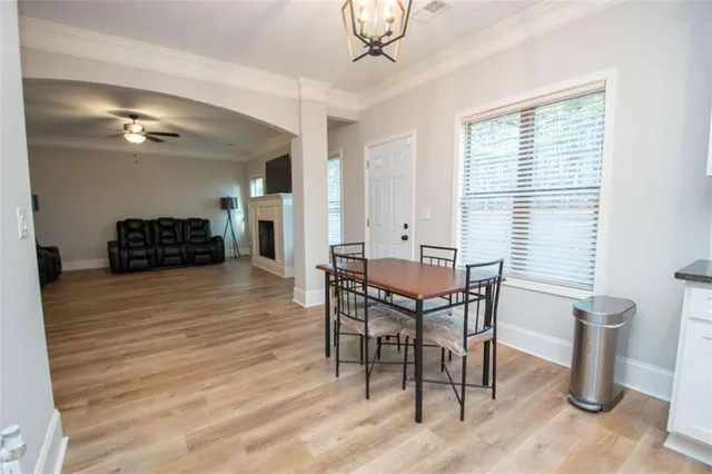 a dining room with furniture a chandelier and wooden floor