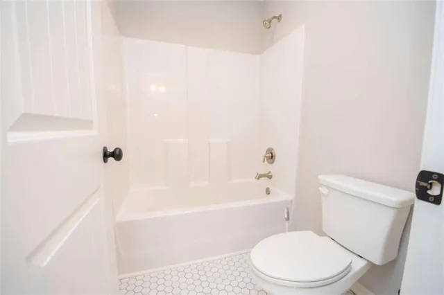 a white toilet sitting next to a bath tub