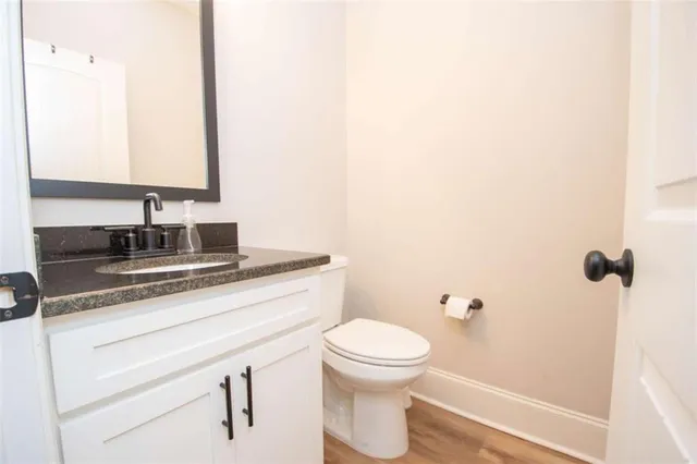 a bathroom with a granite countertop sink toilet and mirror