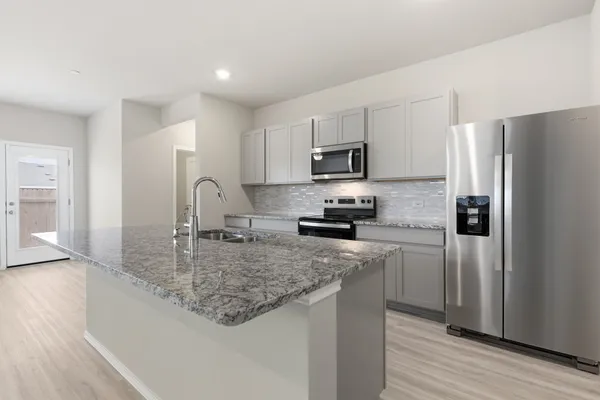 a kitchen with a granite countertop sink window and refrigerator