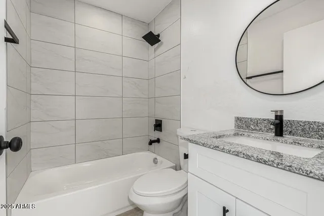 a bathroom with a granite countertop sink a toilet and bathtub