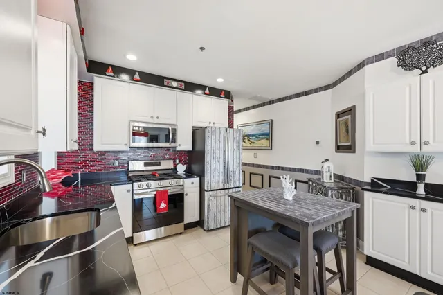 a kitchen with kitchen island granite countertop a table chairs stove and cabinets