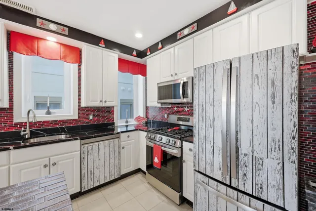a kitchen with stainless steel appliances a stove a sink and a refrigerator